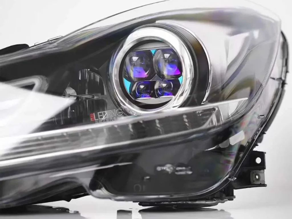 Factory projector headlight module installed inside headlamp housing showing internal structure and mounting integration