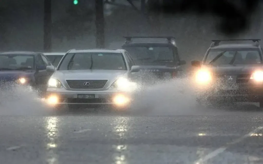 Cars driving on a road in rainy fog with low visibility; fog lamp for car improves close-range visibility.