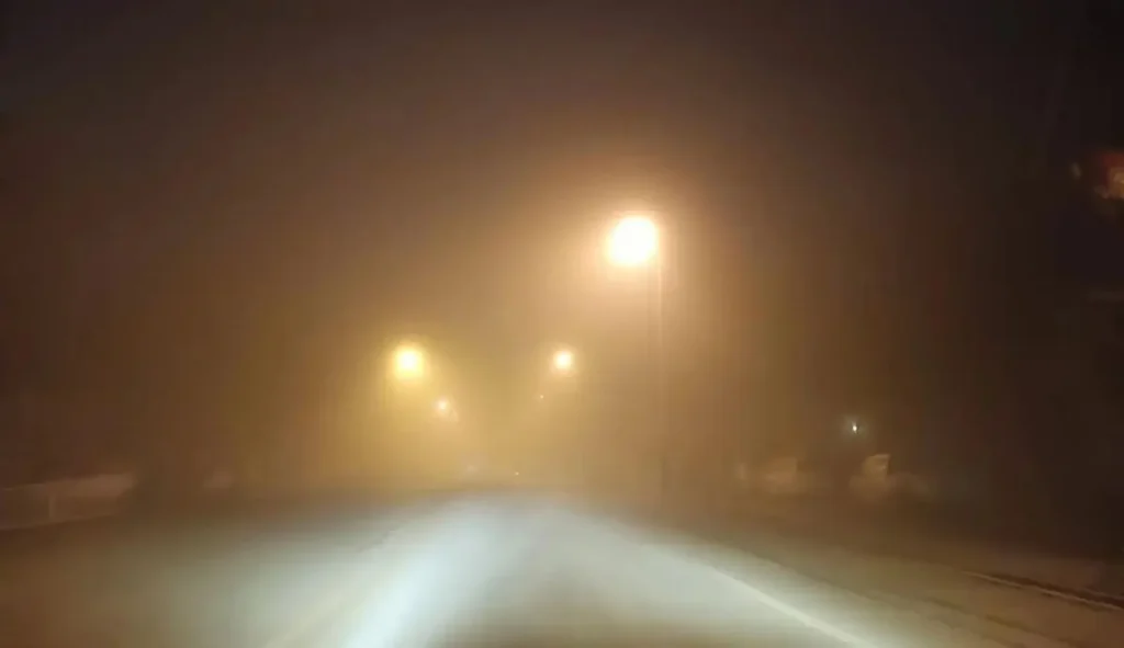 Dense fog on a road with very low visibility (foggy weather driving).