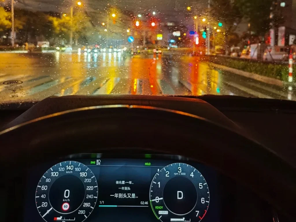 Fog lights creating a bright near-field patch on a rainy wet road, with lane lines less readable and distant road darker.