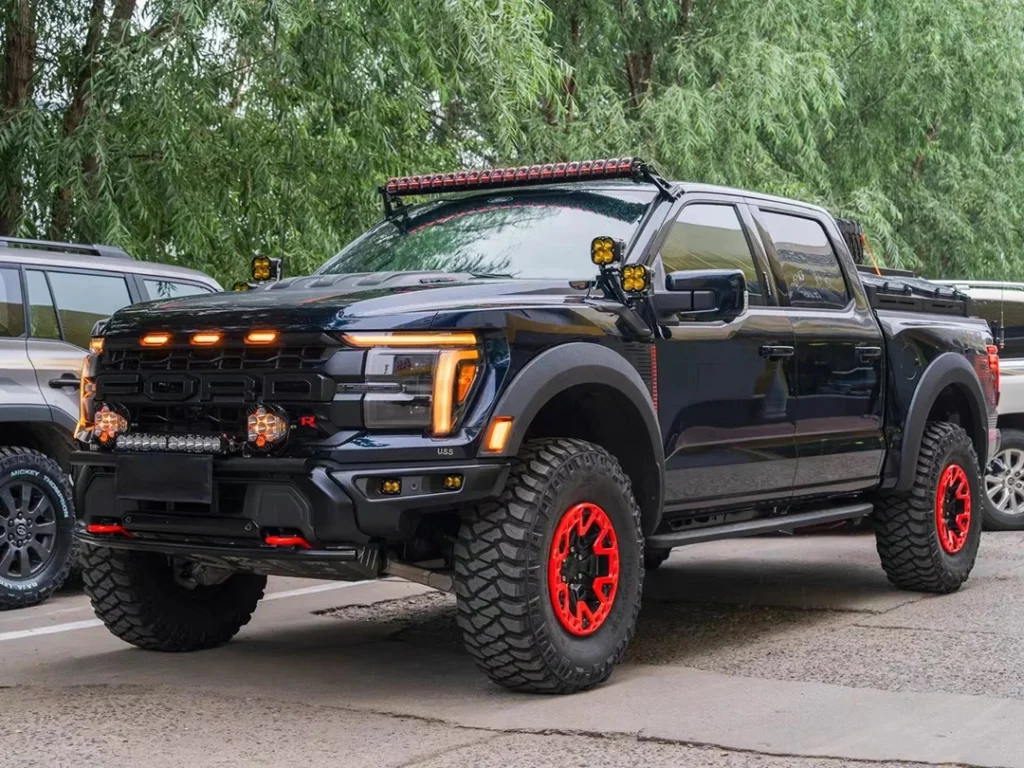 Front view of a modified Ford F-150 Raptor featuring amber grille LED lights, illustrating a commonly compliance-friendly exterior lighting choice (rules vary by region).