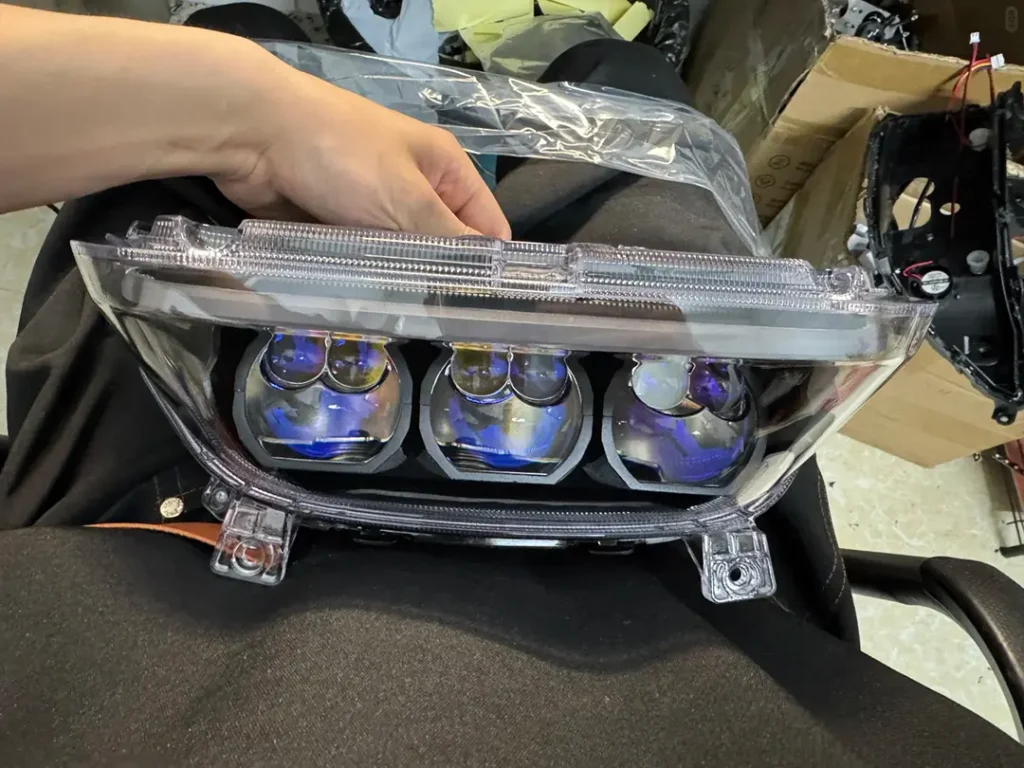 Headlight projector lens mounted inside a motorcycle headlight housing, prepared for installation on the bike