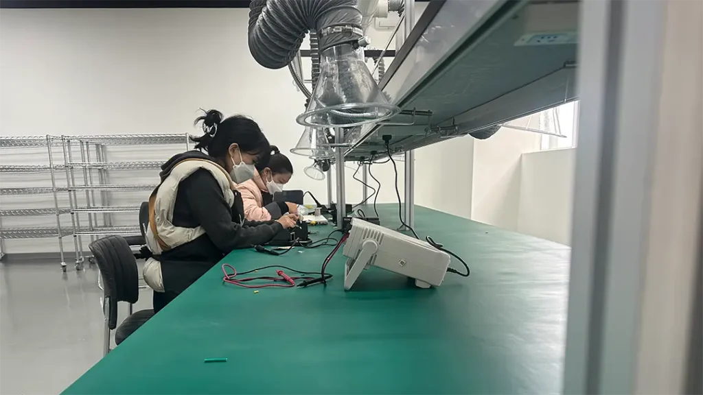 Workers assembling OEM projector headlights on factory production line