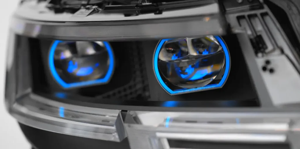 Retrofit projector headlamp after installation, shown without the outer lens cover so the projector lens and mounting hardware are visible.