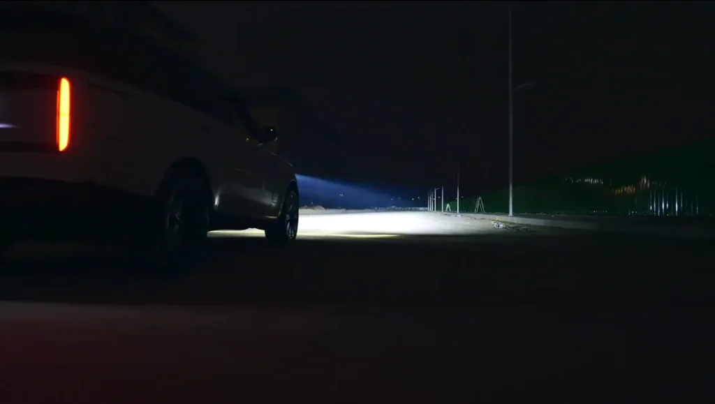 Vehicle on a road test with our projector headlights turned on, showing bright forward illumination
