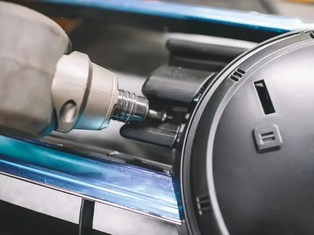 Worker tightening screws with a tool to fasten LED grill lights on a vehicle grille bracket.