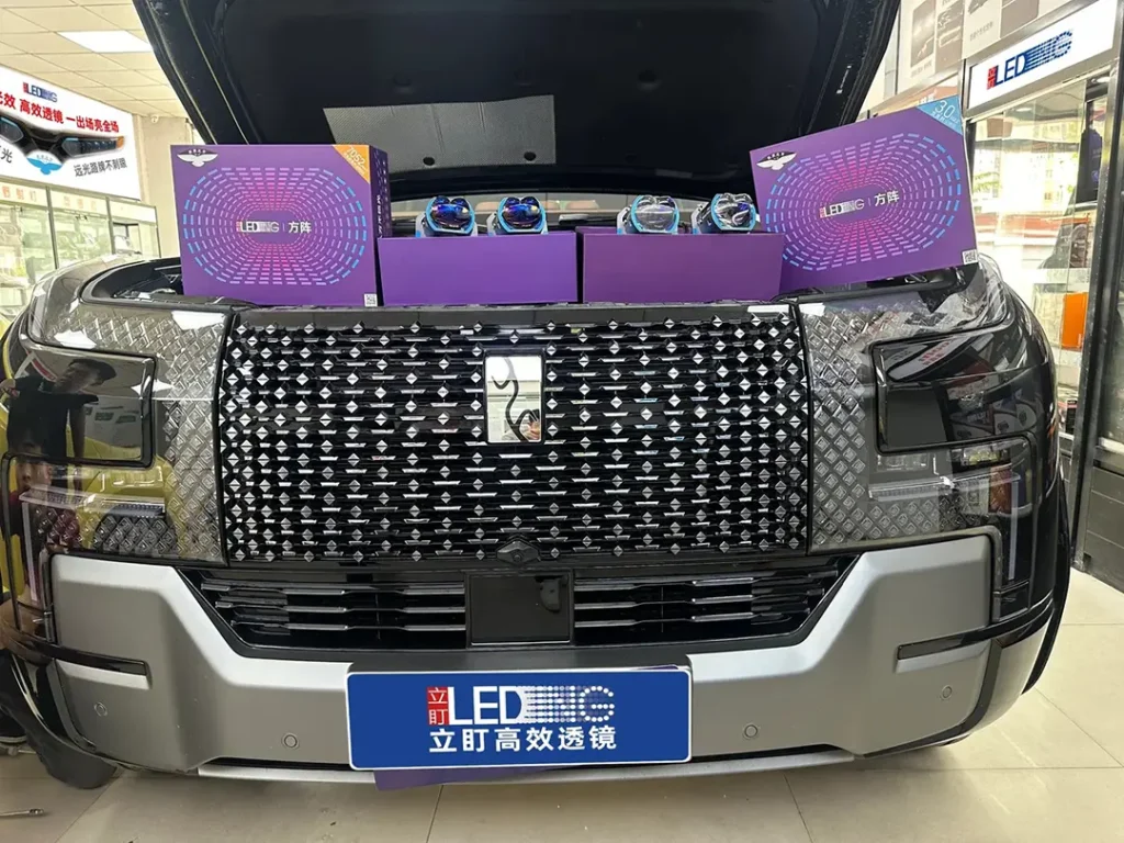 SUV with the hood open, with a projector headlight kit box resting in the engine bay — are projector headlights worth it?