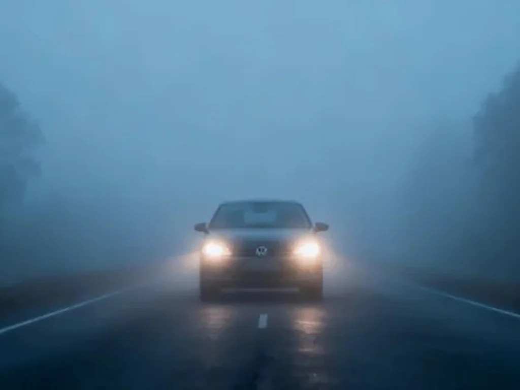 Best fog light for car: low-mounted fog lights on a car in rainy night fog, showing clear road visibility with controlled glare.