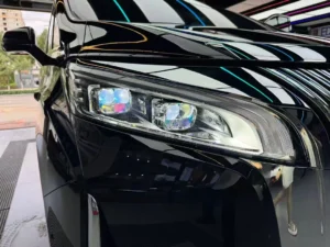 Gros plan sur les phares à projecteur à cinq yeux de Leding installés sur une voiture noire