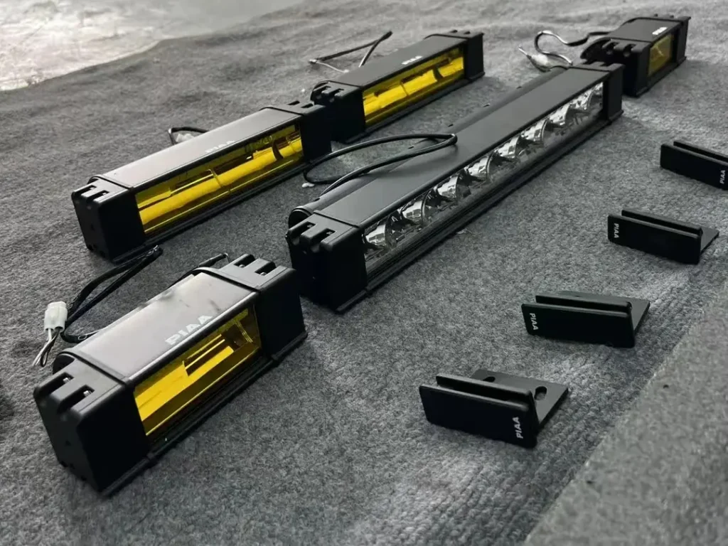 White and amber reflector grille lights with mounting brackets laid out on the ground