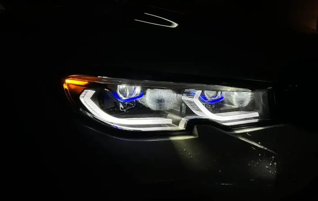 صورة مقرّبة لسيارة سيدان سوداء بمصابيح أمامية عاكسة