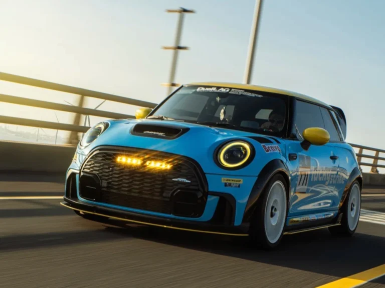 Mini Cooper Biru dengan Lampu Grille Depan terpasang, menampilkan pengaturan LED yang halus di malam hari