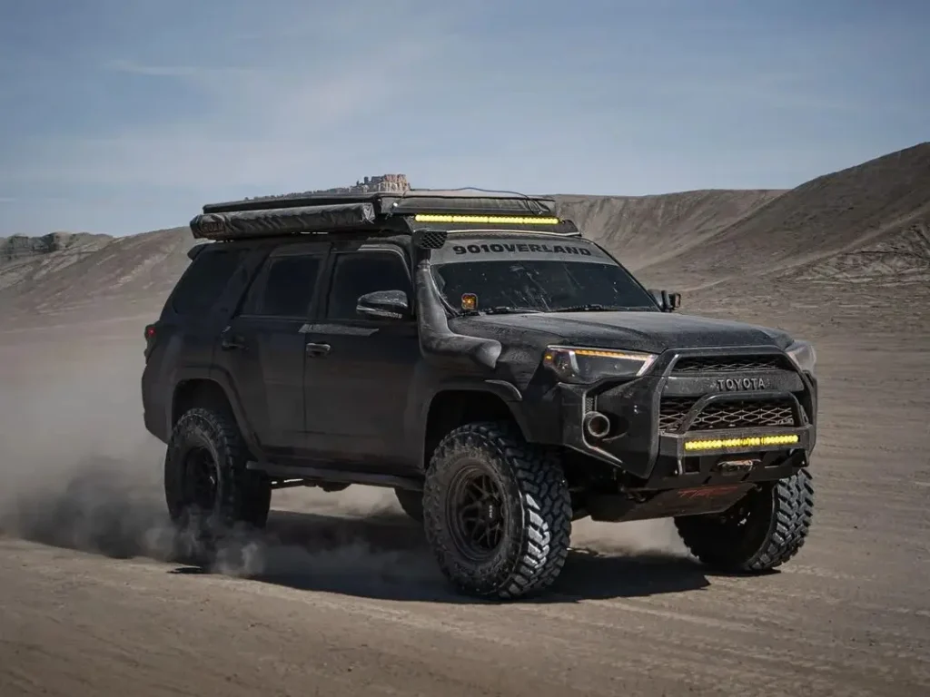 Toyota 4Runner driving in the desert with yellow front grill light bar installed